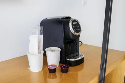 a coffee maker sitting on a table with cups at The Meridian Hotel by At Mine Hospitality in Miami Beach