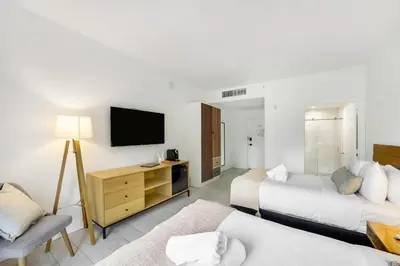 a hotel room with two beds and a flat screen tv at The Meridian Hotel by At Mine Hospitality in Miami Beach