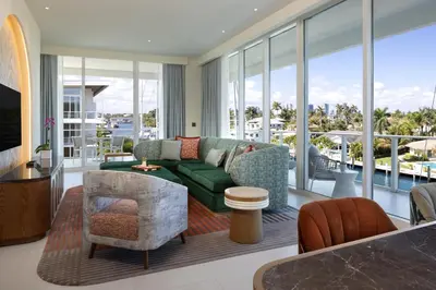 a living room with a green couch and chairs at Pier Sixty-Six in Fort Lauderdale