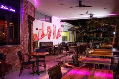 a restaurant with tables and chairs and purple lights at Dream South Beach, by Hyatt in Miami Beach