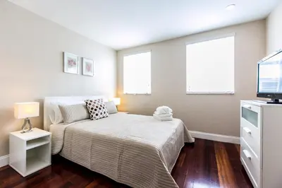 a bedroom with a bed and two windows at Hudson Apartments in Miami Beach