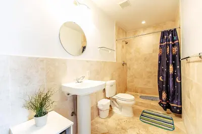 a bathroom with a sink toilet and a mirror at Hudson Apartments in Miami Beach
