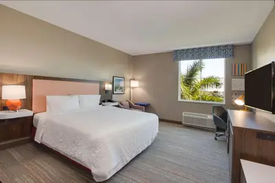 a hotel room with a bed and a flat screen tv at Hampton Inn & Suites Fort Lauderdale - Miramar in Miramar