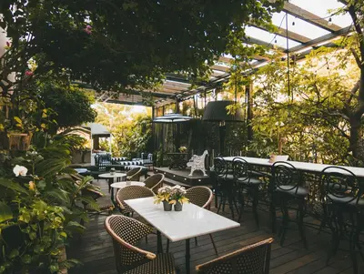 an outdoor patio with tables and chairs and plants at Cadet Hotel in Miami Beach