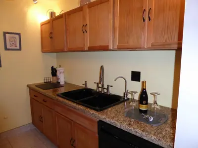 a kitchen counter with a sink and a bottle of wine at PlayaBlanco Suites in Fort Lauderdale