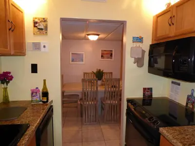 a kitchen with a microwave and a dining room at PlayaBlanco Suites in Fort Lauderdale