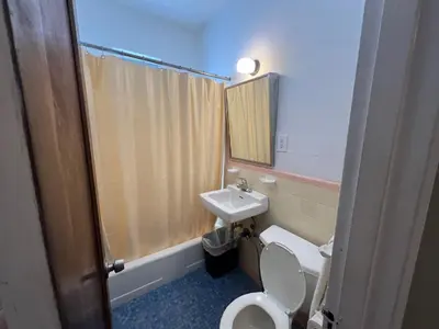 a bathroom with a toilet and a sink at Sherbrooke All Suites Hotel in Miami Beach
