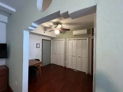 a living room with a ceiling fan and a table at Sherbrooke All Suites Hotel in Miami Beach