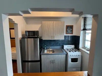 a small kitchen with a stove and a sink at Sherbrooke All Suites Hotel in Miami Beach