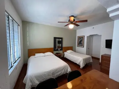 a bedroom with two beds and a ceiling fan at Sherbrooke All Suites Hotel in Miami Beach