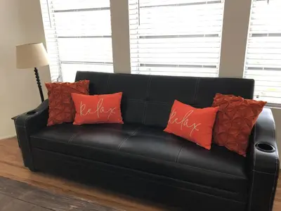a black leather couch with red pillows on it at Beach Place Hotel in Miami Beach