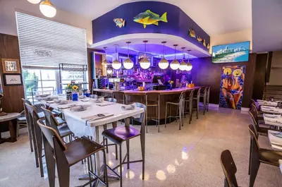 a restaurant with a bar with tables and chairs at Oceanside Hotel and Suites in Miami Beach