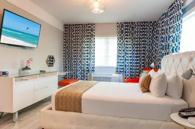 a bedroom with a large bed and a television at Oceanside Hotel and Suites in Miami Beach