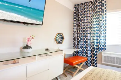 a bedroom with a desk and a chair and a window at Oceanside Hotel and Suites in Miami Beach