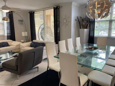 a dining room with a glass table and white chairs at The Nautical! Amazing 3Bed 2Bath Apartment at Aventura Yacht Club in Aventura