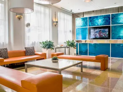a living room with orange furniture and a tv at Clevelander Hotel in Miami Beach