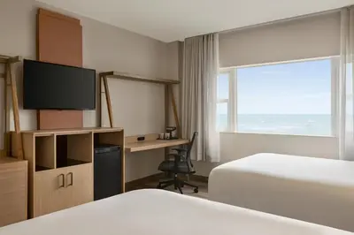 a hotel room with two beds and a desk with a television at Lexington by Hotel RL Miami Beach in Miami Beach
