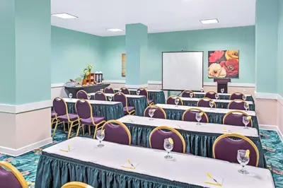 a conference room with tables and chairs and a screen at Lexington by Hotel RL Miami Beach in Miami Beach