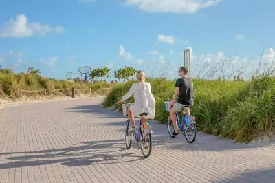 a man and a woman riding bikes down a road at Parisian Hotel in Miami Beach