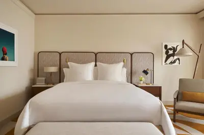 a bedroom with a large white bed and a chair at Four Seasons Hotel Miami in Miami
