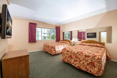 a hotel room with two beds and a television at Geneva Hotel in Miami Beach