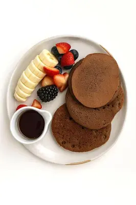 a plate of chocolate muffins and fruit and a cup of coffee at Nassau Suite South Beach, an All Suite Hotel in Miami Beach