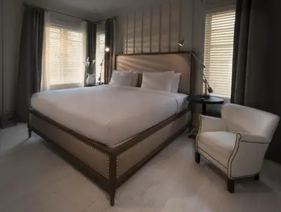 a bedroom with a large bed and a chair at Shepley South Beach Hotel in Miami Beach