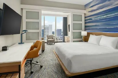 a hotel room with a bed and a desk and a computer at Courtyard by Marriott Oceanside Fort Lauderdale Beach in Fort Lauderdale