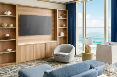 a living room with a blue couch and a television at Courtyard by Marriott Oceanside Fort Lauderdale Beach in Fort Lauderdale