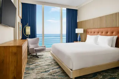 a hotel room with a bed and a large window at Courtyard by Marriott Oceanside Fort Lauderdale Beach in Fort Lauderdale