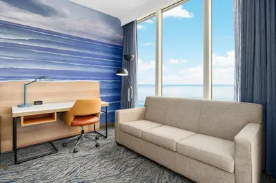 a living room with a couch and a desk at Courtyard by Marriott Oceanside Fort Lauderdale Beach in Fort Lauderdale