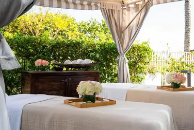 two tables with white linens and flowers in vases at Cadillac Hotel & Beach Club, Autograph Collection in Miami Beach