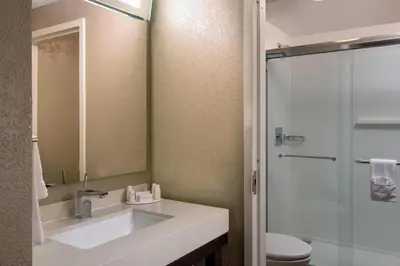 a bathroom with a sink and a toilet and a mirror at Courtyard Miami Beach South Beach in Miami Beach