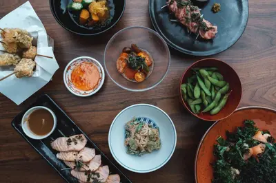 a wooden table topped with different dishes of food at Marriott Stanton South Beach in Miami Beach