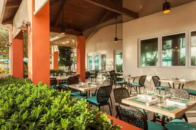 a restaurant with tables and chairs and windows at Hollywood Beach Marriott in Hollywood
