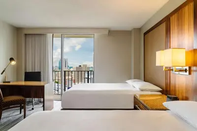 a hotel room with two beds and a desk and a balcony at Hyatt Regency Miami in Miami