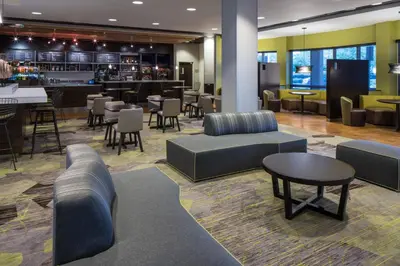 a lobby with couches and tables and a bar at Courtyard by Marriott Miami West/FL Turnpike in Miami