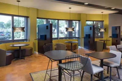 a restaurant with tables and chairs and windows at Courtyard by Marriott Miami West/FL Turnpike in Miami