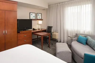 a hotel room with a bed and a desk with a television at Courtyard by Marriott Miami West/FL Turnpike in Miami
