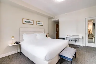 a bedroom with a large white bed and a desk at Crest Hotel Suites in Miami Beach