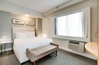 a bedroom with a large white bed and a window at Crest Hotel Suites in Miami Beach