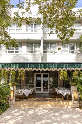 a hotel with tables and chairs in front of a building at Crest Hotel Suites in Miami Beach