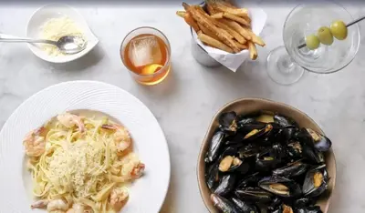 a table with a plate of food with mussels and pasta at Liberty Park Hotel South Beach in Miami Beach
