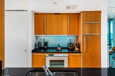 a kitchen with wooden cabinets and a sink at Oceanfront Private Condo at The Setai -2208 in Miami Beach
