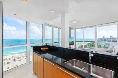 a large kitchen with a view of the ocean at Oceanfront Private Condo at The Setai -2208 in Miami Beach