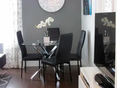 a dining room table with chairs and a clock on the wall at Ocean Blue in Miami Beach