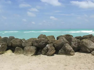 a pile of rocks on a beach near the ocean at Ocean Blue in Miami Beach