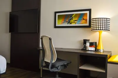 a room with a desk with a chair and a lamp at Best Western Plus Ft Lauderdale Hollywood Airport Hotel in Hollywood