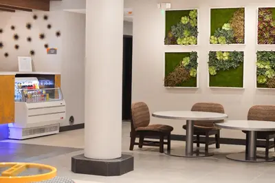 a room with two tables and chairs and paintings on the wall at Best Western Plus Ft Lauderdale Hollywood Airport Hotel in Hollywood