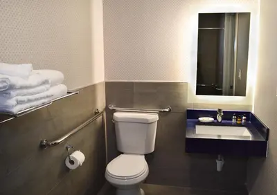 a bathroom with a toilet and a sink and towels at Best Western Plus Ft Lauderdale Hollywood Airport Hotel in Hollywood